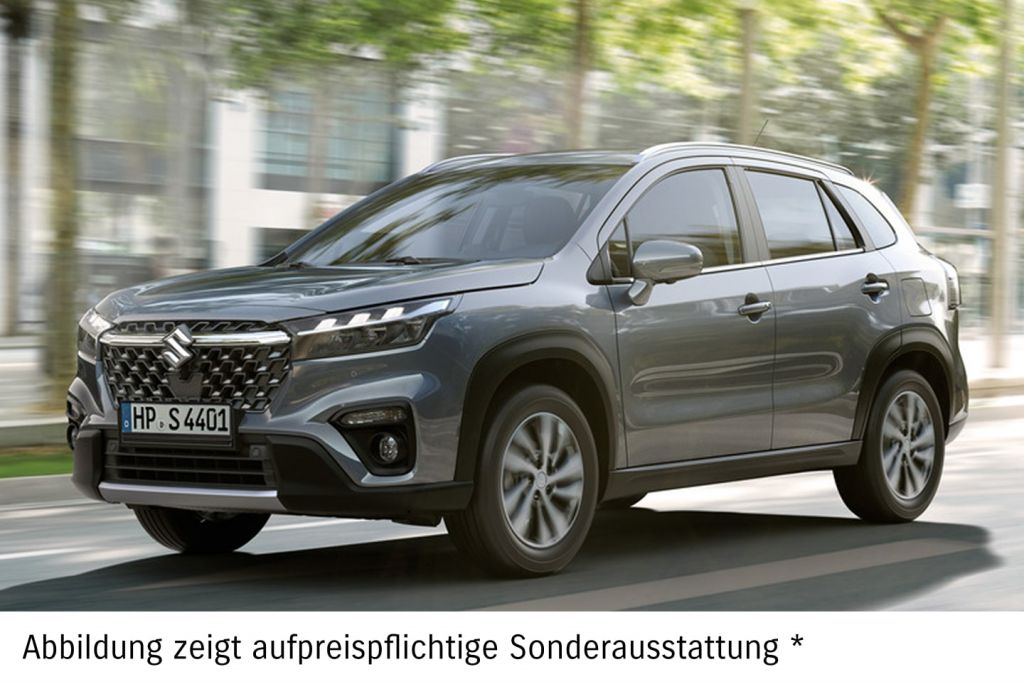Dunkelgrauer Suzuki S-Cross fährt auf einer Straße mit Bäumen im Hintergrund.