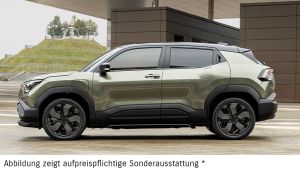 Grüner Suzuki e Vitara in Seitenansicht vor einer Hauswand.