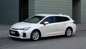 Weißer Suzuki Swace Hybrid in Front-Seitenansicht vor City-Setting 