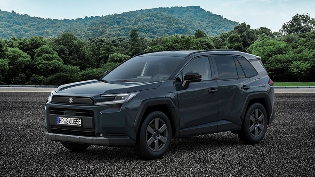Weißer Suzuki Across Hybrid in Seitenansicht vor City-Setting und Betonwand