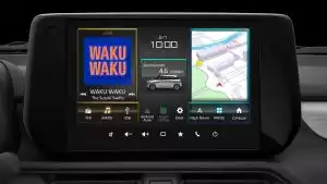 Nahaufnahme des 9 Zoll Farb-Touchscreens des Suzuki Swift Hybrid mit Musikanzeige, Navigation, Uhrzeit und Verbrauch