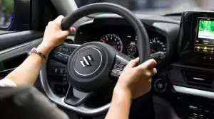 Nahaufnahme des Swift-Cockpits über die Schulter der Fahrerin, die beide Hände am Lenkrad hat