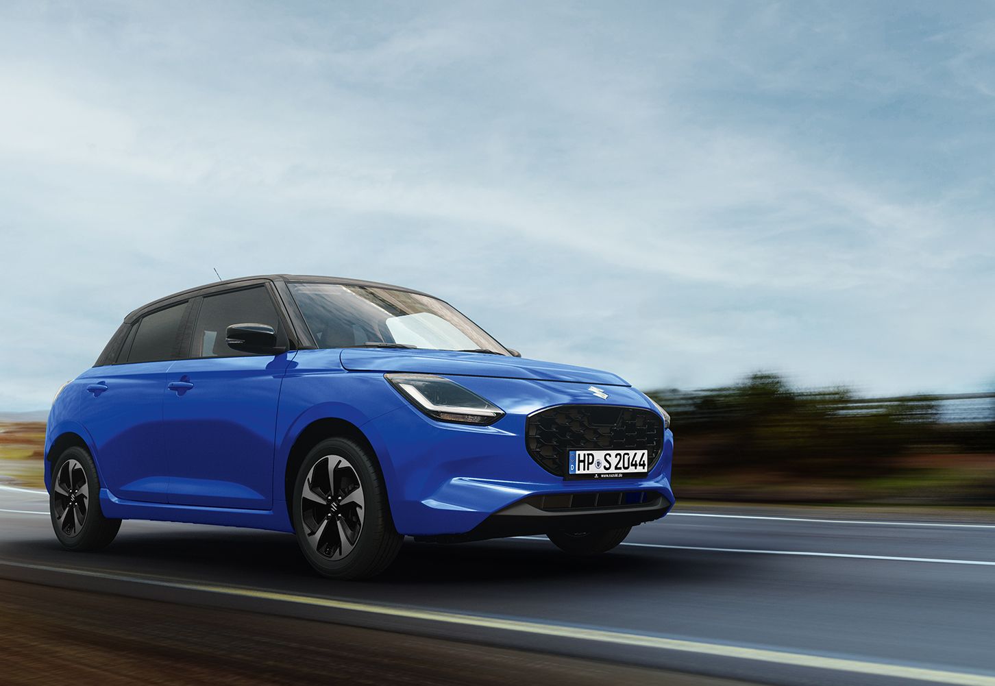 Blauer Suzuki Swift fährt auf Landstraße