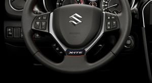 Lenkrad des Suzuki Vitara X-ITE mit X-ITE Emblem und orangefarbenen Akzenten.
