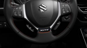 Lenkrad des Suzuki S-Cross X-ITE mit X-ITE Emblem und orangefarbenen Nähten.