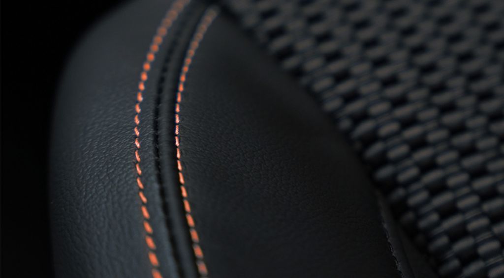 Detailaufnahme der orangefarbenen Ziernähte im Innenraum des Suzuki S-Cross X-ITE.