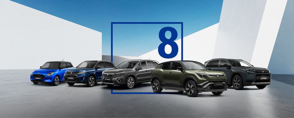 Die Suzuki Modelle – Swift, S-Cross, Vitara, e VITARA und Across – stehen vor einer grafischen Hintergrundkulisse weiß und blau. Im Bild ist ein grafisches Symbol, die Zahl 8 in einem blauen Rahmen. .