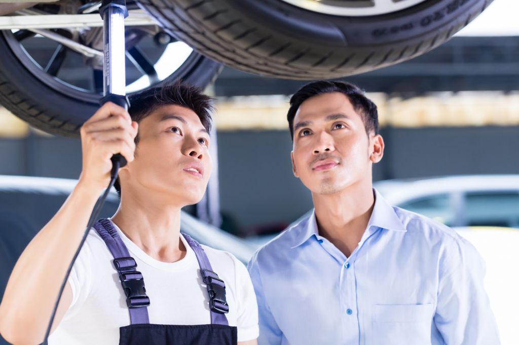 Mechaniker prüft Rad von Auto auf Hebebühne